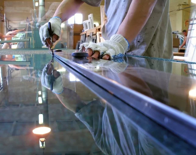 Operario cortando vidrio en el taller